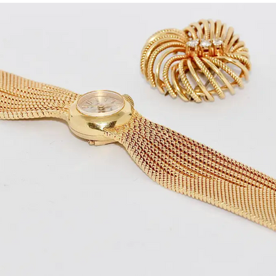 Universal Genève Damenarmbanduhr aus 18 Karat Gold mit Diamanten – multifunktional als Uhr & Brosche